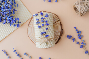 Beeswax candle with lavender tied on wood slice flatlay