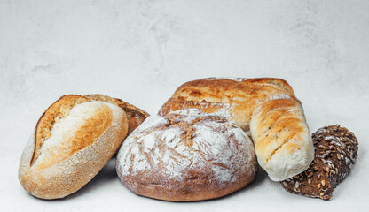 Fresh assorted types of bread on a textured surface ready for serving