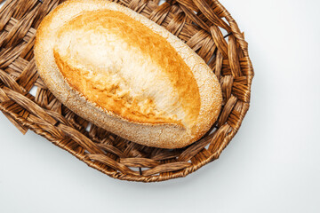 Freshly baked bread in a woven basket on a light background
