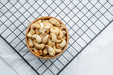 Delicious cashew nuts in wooden bowl on cooling rack ready for snacking