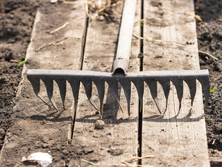 A metal rake with a wooden handle