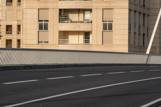 Modern empty street with geometric lines and shadows under warm sunlight, ideal for copy space or background usage in contemporary urban design and mobility concepts.