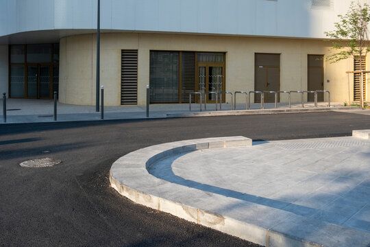 Curved urban street corner with clean textures and sunlight, minimalistic architecture backdrop perfect for business and mobility related themes and advertising.