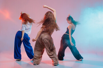 Three Young Women Dancing Jazz Funk in Studio with Colorful Lights and Dynamic Urban Movement