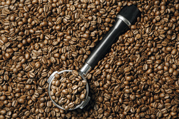 Top View of Portafilter Filled With Roasted Beans Amongst Bed of Coffee Beans