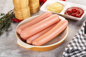 Boiled sausages with ketchup and mustard