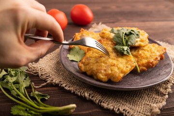 Fried crispy Chicken pancakes with hand on brown wooden. side view, selective focus