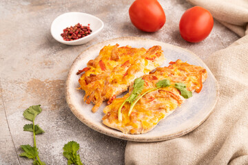 baked chicken meat with cheese and tomatoes on brown concrete. side view, close up