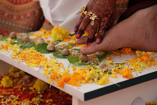 a traditional Indian wedding ritual, specifically a moment from the "Saptpadi" or "Mangal phera" .bride placing her foot on the groom's foot