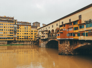 ponte vecchio florence italy with water reflections and cloudy sky