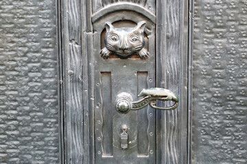 Vintage Cat-Themed Door Knocker on Rustic Metal Surface