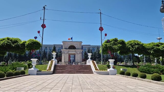CHISINAU, MOLDOVA - JUNE 20, 2025 Triumphal Arch as popular historical landmark of the capital with the Moldovan Government House in the background