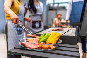 Chefs preparing meat, corn and vegetables for barbecue grill