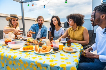 Friends enjoying rooftop barbecue party with delicious food