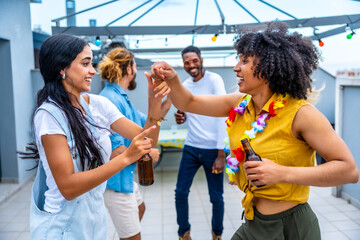 Friends enjoying drinks and dancing at rooftop party