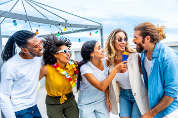 Friends singing karaoke at rooftop party, enjoying summertime together