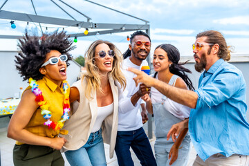 Friends singing karaoke at rooftop party having fun
