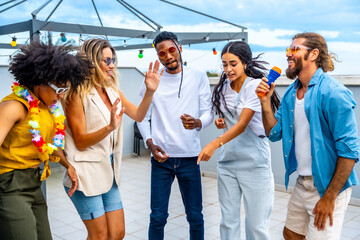 Friends singing karaoke and dancing at rooftop party