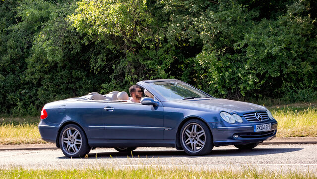 Milton Keynes,Bucks,UK - June 16th 2025: 2004 blue Mercedes Benz clk convertible car driving on a British road