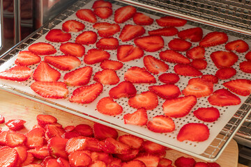 Food Dehydrator. Strawberries being dehydrated on racks in a machine. Strawberries, fresh berries on pallets. High quality photo