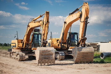Construction machinery working on site during bright day with clear sky and scattered clouds