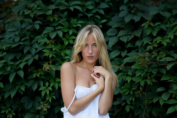Outdoor portrait of beautiful young woman with green eyes at summertime.