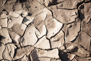 Dry cracked earth reveals unique textures in an arid landscape during daylight hours