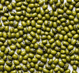 A high angle close up shot of a dense pile of vibrant green mung beans scattered on a flat surface