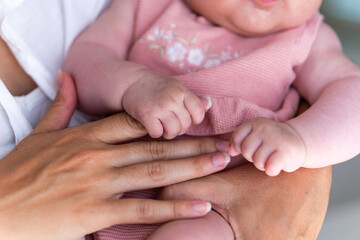A gentle embrace captures the interaction between an adult and a newborn, highlighting tiny hands...