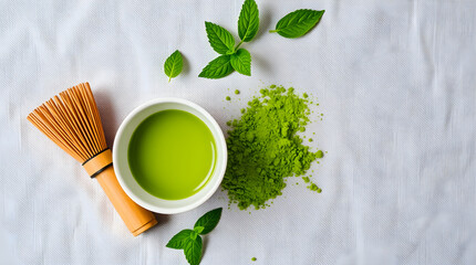 Matcha tea accessories with green powder and mint leaves on white background