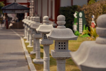 A row of traditional stone lanterns is lined up in front of a historic building