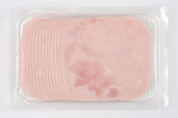 A clear plastic package contains neatly stacked slices of light pink ham, ready for consumption