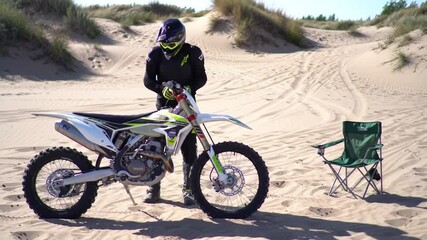 Biker, motorbike and man with chair in outdoor training to start for extreme sports, safety and practice on sand. Seat, ready and driver with gear for dunes, race or cycling in challenge on holiday