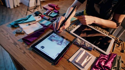 shion designer using digital pen to draw sketches on tablet, surrounded by various fabrics, color swatches, and sewing accessories . Concept fashion designer innovative uplifting fashion designer.