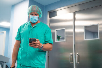 Surgeon using smartphone in hospital corridor