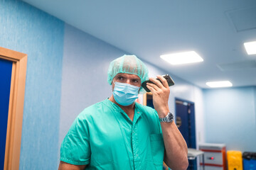 Surgeon using smartphone in hospital corridor