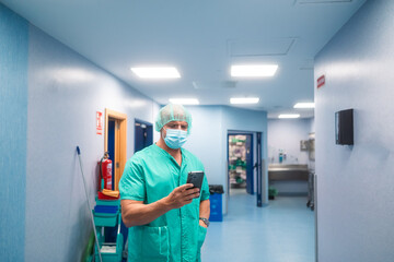 Surgeon using smartphone in hospital corridor