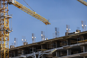 Construction site with tower crane. House and buildings construction. Hotel apartments...