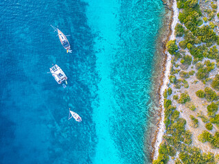 Sail boat and catamaran at a bay on blue turquoise water. Anchor in paradise