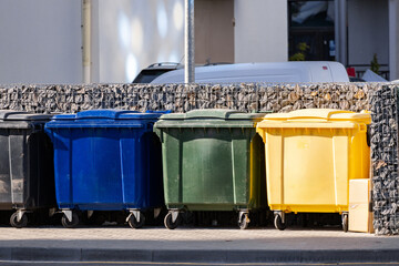 A group of wheeled waste containers for recycling garden waste and general street waste.