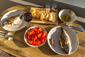 Grilled fish, dorada, glass of wine, dinner, wine from Croatia, red tomatoes, olive oil, fresh...