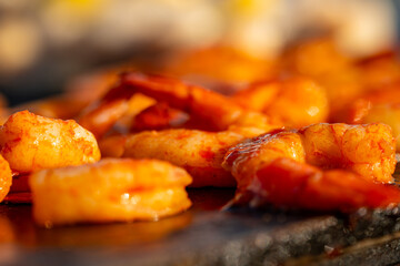 Nourriture variée en train de cuire sur une plancha extérieure, avec vapeur et grillades appétissantes.
