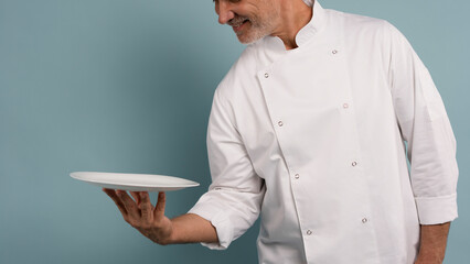 Portrait of chef, empty plate and smile, presenting menu special promo deal or restaurant product placement
