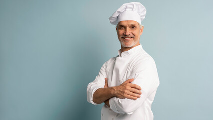 Happy chef in uniform on blue background.