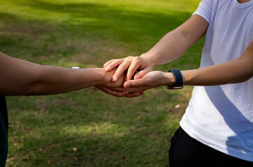 Man hand as lending a helping hand as trust together with compassion concept as lens flare scene at park