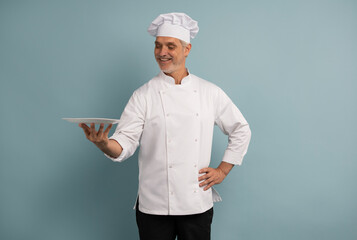 Portrait of chef, empty plate and smile, presenting menu special promo deal or restaurant product placement