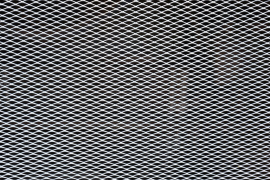 White expanded metal mesh on black background. 
