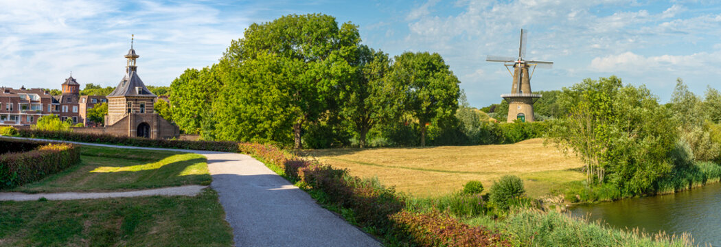 Panorama of historical city gate Dalempoort and a traditonal dutch windmill in the city of Gorinchem, South Holland, The Netherlands