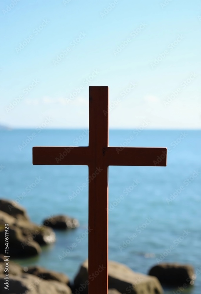Poster a wooden cross stands tall near the water, creating a striking silhouette against the tranquil sea. 