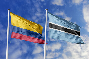 Flags of Colombia and Botswana Waving Together Against a Bright Blue Sky, Symbolizing Diplomatic Relations and Global Partnership.